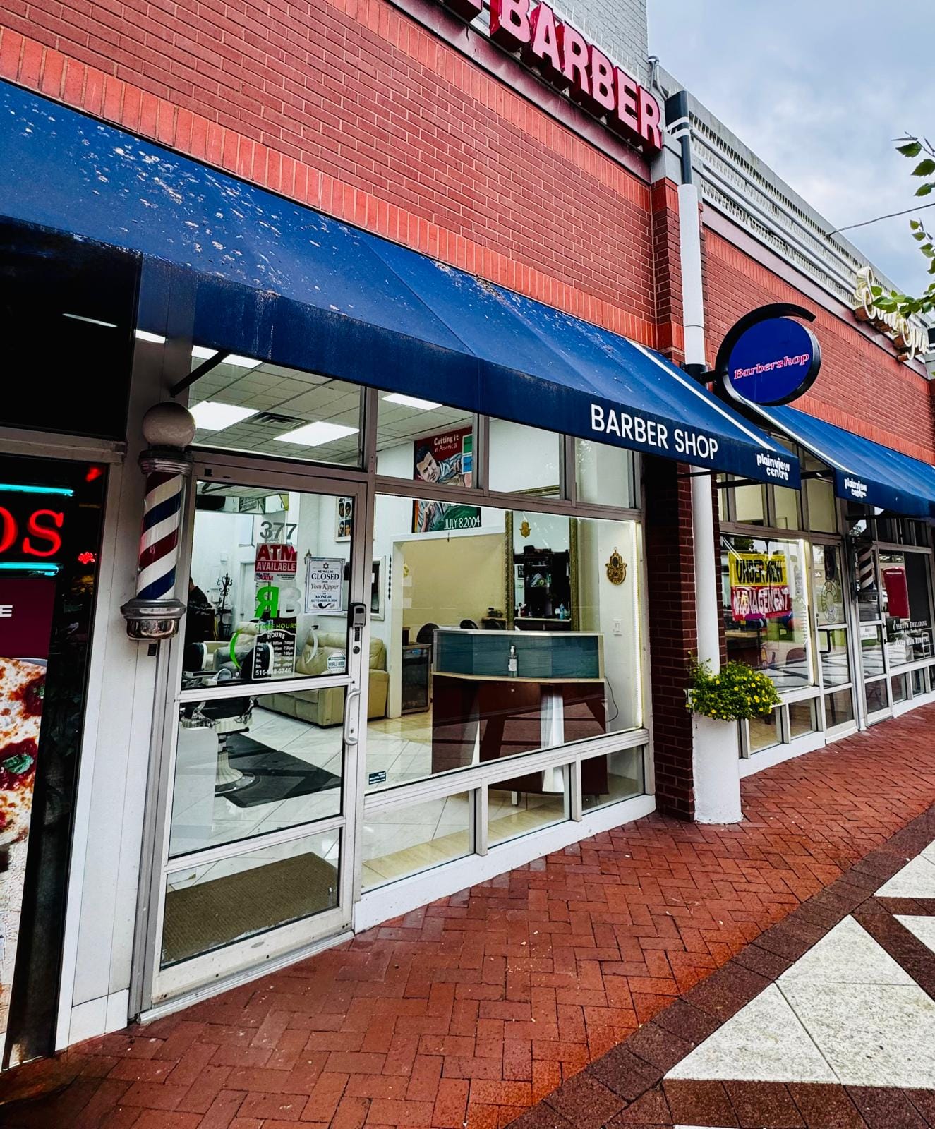 The Top Notch Barbers storefront under the blue awning at 377 S Oyster Bay Rd, Plainview Centre